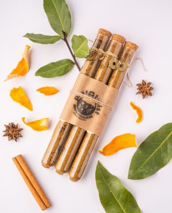 Frasco de banhos de ervas para prosperidade da Quinta Figaradeiro em vidro com rolha de cortiça, contendo mistura de plantas secas, sobre fundo claro.